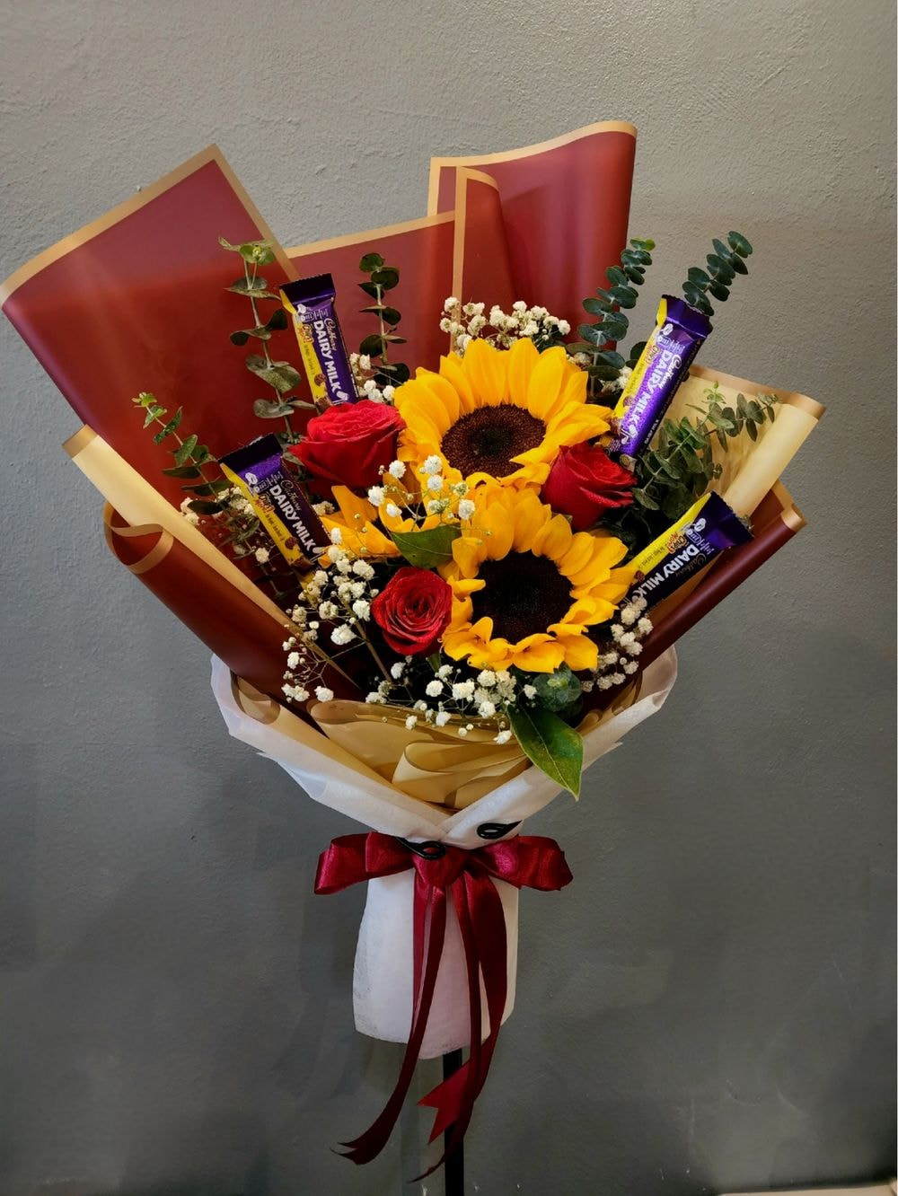 Roses + Sunflower + Cadbury Medium size: 3 Roses & 2 Sunflowers with eucalytus and baby breath arrangements with 4pcs Cadbury