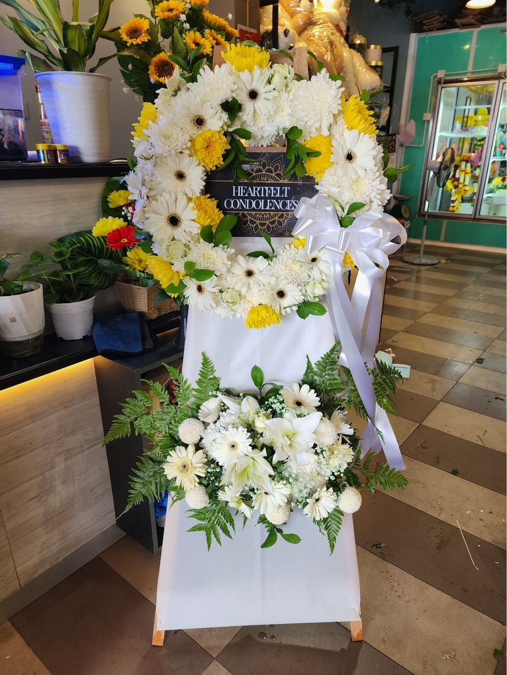  Express your sympathy and condolences with our Two Tier Wreath with Wood Stand