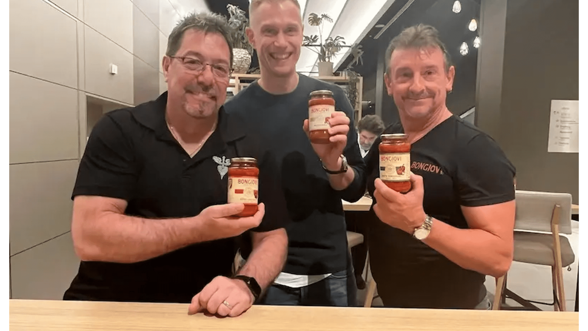 „Drei Personen präsentieren Bongiovi Pastasaucen in einem Restaurant – authentische Begegnung mit der Marke.“ „Drei Personen präsentieren Bongiovi Pastasaucen in einem Restaurant – authentische Begegnung mit der Marke.“