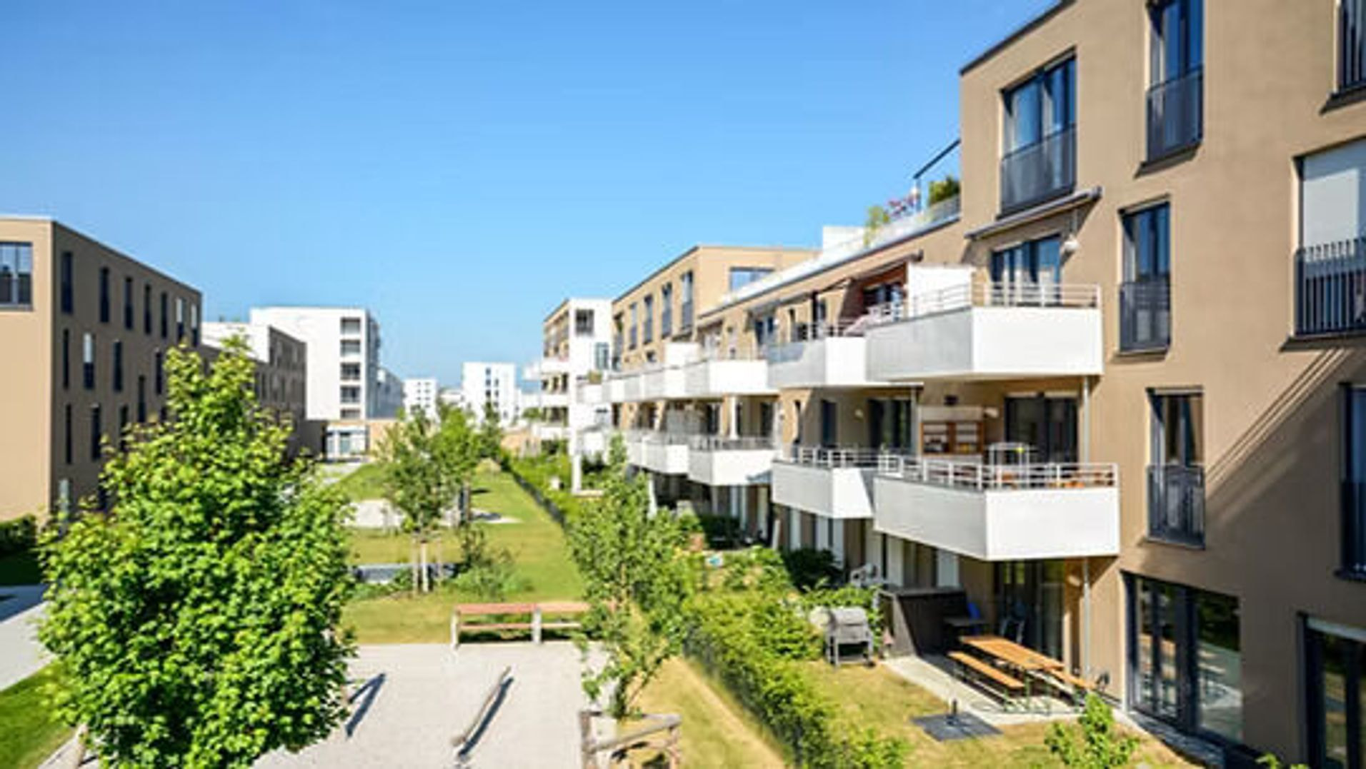 Moderner Wohnkomplex mit grüner Parkanlage und Balkonen