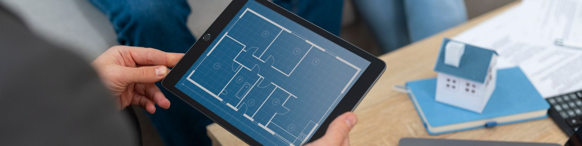 Agente immobiliare mostra una planimetria digitale a una coppia su un tablet Agente immobiliare mostra una planimetria digitale a una coppia su un tablet